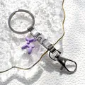 Dettaglio del portachiavi in acciaio inox con cane palloncino viola su vassoio - Cane Palloncino