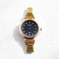 Détail d'une montre à quartz dorée avec index en diamant et aiguilles bleues sur blanc - BARSH Cadran Noir à Échelle de Strass Rond (7)