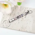 Detail of Italian link keychain with stainless steel charms: piano, note, and ballet shoes - Music and Dance Theme