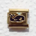 Macro shot of gold Italian charm link with blue enamel whale and water spray design - Whale