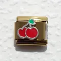 Detalle de eslabón italiano de acero inoxidable dorado con diseño de cerezas rojas - Cereza