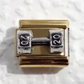 Macro shot of a gold-plated Italian charm featuring a silver dumbbell with number 20 - Weightlifting
