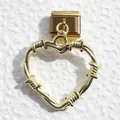 Macro detail of golden heart charm with metal wire-wrapped design on Italian link bracelet - Industrial Woven Heart Style