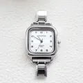 Macro detail of silver square quartz watch with textured white dial and metal link bracelet - White Textured Dial Arabic Numerals Style