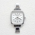 Detail of silver square quartz watch with white dial and polished steel band on texture - Rounded Square Matte White Dial Bar Index Style