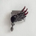Détail macro du charm italien avec ailes de chauve-souris noires et gemme poire rouge - Style Aile 2