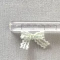 Vista macro de un lazo de encaje hecho a mano verde menta de 2,5 cm con regla de medida - Verde Menta(4)