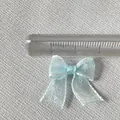 Close-up of 2.5cm light blue organza ribbon bow with delicate metallic edge stitching - Light Blue