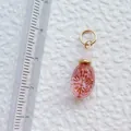Macro shot of pink acrylic pendant with gold pattern and size scale reference - Pink Radial Pattern Oval Pendant (3)