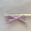 Dettaglio di un fiocco in tessuto viola fatto a mano con un righello per scala di 8cm - Stile Viola (4)