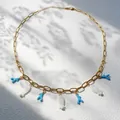 Gouden ketting met blauwe koraal- en witte vishangers in zomerse vakantiestijl - Koraal Vis Ketting