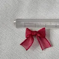 Macro view of a 3cm burgundy organza bow accessory with detailed stitched edges and ruler - Dark Red