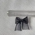 Close-up of 2cm mini black organza ribbon bows for DIY nail art and doll clothing - Black