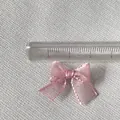 Macro shot of 2.5cm mini pink organza ribbon bow with glitter thread for DIY crafts - Pink Glitter Silk