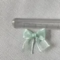 Close-up of a 2cm mint green organza bow with pearl finish for DIY nail art and crafts - Mint Green
