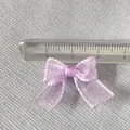 Detailed view of a 2.5cm light purple organza bow with fine edging on textured fabric - Light Purple