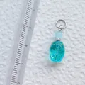 Detailansicht eines wasserblauen Acryl-Anhängers mit Lineal zur Größenanzeige für DIY - See-blauer ovaler Anhänger mit Radialmuster (17)