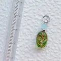 Detailansicht des handgefertigten Lebensbaum-Anhängers mit hellblauer Perle und Metallöse - Grüner Anhänger mit Lebensbaum-Muster (21)
