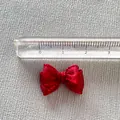 Macro shot of a 3cm mini red organza ribbon bow measured with a clear scale ruler - Bright Red
