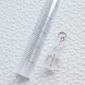 Makro-Detail eines geometrischen Acryl-Anhängers mit Lineal zur Größenmessung - Anhänger mit klarem Würfel und hellblauer Perle (27)