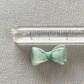 Close-up of a 2cm mint green organza bow with ruler showing size for DIY crafts - Mint Fabric