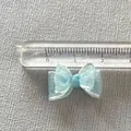 Close-up of a 2.5cm light blue organza ribbon bow accessory with measurement ruler - Light Blue