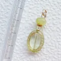 Detailansicht eines gelben Acryl-Anhängers mit Goldgravur und 3,8 cm Größenmessung - Hellgelber ovaler Vintage-Prägeanhänger (32)