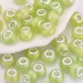 Primer plano de cuentas de resina verde claro con purpurina para joyería artesanal - Verde claro