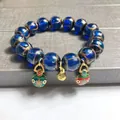 Blue glass beaded bracelet with golden gourd and enamel lucky bag charms on grey stone - 10mm / Blue