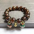 Amber glazed bead bracelet with golden gourd and enamel flower bell charms - Brown