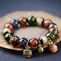 Ethnic glass beaded bracelet with colorful charms and bell on bronze display - 10mm / Multicolor