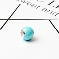 Macro shot of light blue round charm bead with silver dot patterns for charm bracelets - Blue