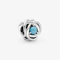 Detailed shot of woven silver charm featuring a central light blue round gemstone - Emerald Blue
