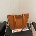 Caramel brown frosted tote bag in large capacity with sleek leather straps on a chair - No Pendant / Brown