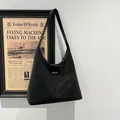 Schwarze Hobo-Schultertasche mit großem Fassungsvermögen, matter Lederstruktur und Golddruck - Schwarz