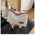 Beigefarbene Canvas-Tasche mit braunem Lederriemen und modischem Label-Detail - Kaffeebraun