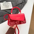 Chic red faux leather handbag with letter embossing and elegant gold lettering - Red