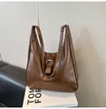 Close-up of vintage dark brown PU leather shoulder bag with silver buckle on a bench - No Pendant / Brown