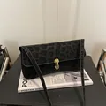 Dettaglio della borsa a tracolla leopardata nera con elegante chiusura a scatto dorata - Nero