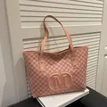Pink tote bag featuring letter M pattern prints and large embossed oval logo detail - Pink Without Pendant