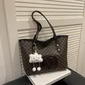 Brown monogram tote bag with large M logo and white cloud plush charm in a chic setting - Coffee With Pendant
