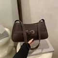 Minimalist dark brown underarm baguette bag with decorative buckle strap detail - Brown