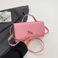 Rosafarbene Umhängetasche mit Webmuster, goldener Knotenschließe und Trageriemen - Rosa