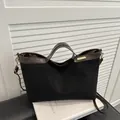 Women's black suede tote bag with brown leather handles and golden metal logo - Black