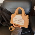 Detail van de BEPRO-tas met canvas stiksels, lederen handvaten en gouden metalen beslag - Khaki