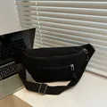 Close-up of black corduroy waist bag with dual metal zippers on a modern desk setup - Black