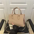 Detailansicht der beigefarbenen Handtasche mit vertikalen Streifen und Rundgriffen - Khaki