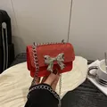 Mini borsa rossa con paillettes e un grande fiocco metallico argento con catena - Rosso