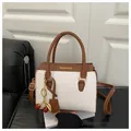 White pebbled leather shoulder bag with brown trim and cute cherry charm accessory - White