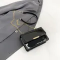 Glossy black patent leather crossbody bag with elegant gold buckle and chain strap - Black